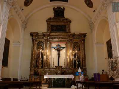 Non ci resta ora che aspettare la fine della messa per poter ammirare gli interni. La chiesa si presenta con una navata unica lunga 16 metri e coperta da volta a botte, alla fine della quale troneggia un imponente altare di legno dorato del XVI secolo nel cui riquadro centrale si trova un crocifisso ligneo di fine 400